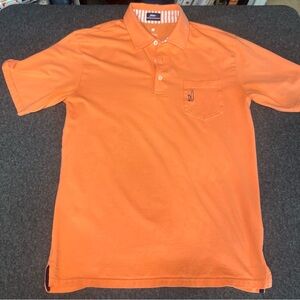 Johnnie-O Featherweight Performance Polo shirt in a salmon color.
